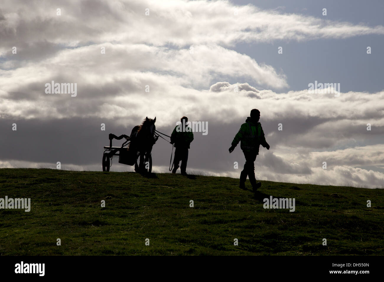Silhouette der zwei Männer und ein Pferd und Wagen auf die Malvern Hills, Worcestershire, England, UK Stockfoto