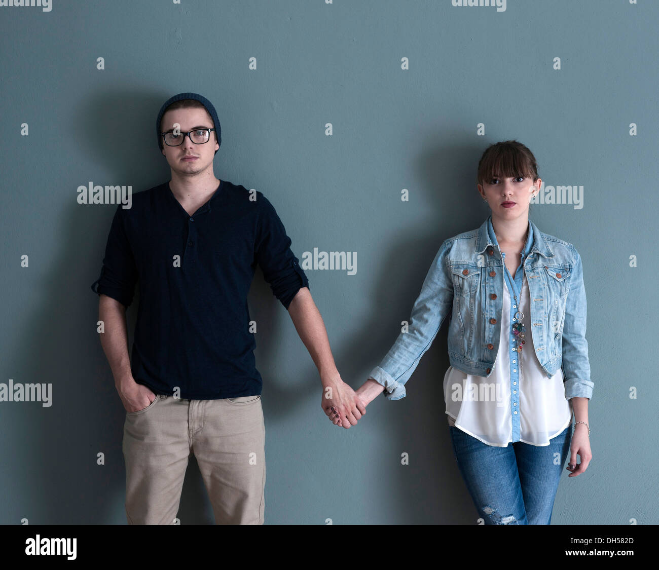 Junge Paar vor einer Wand stehen, hand in hand Mannheim, Baden-Württemberg, Deutschland Stockfoto