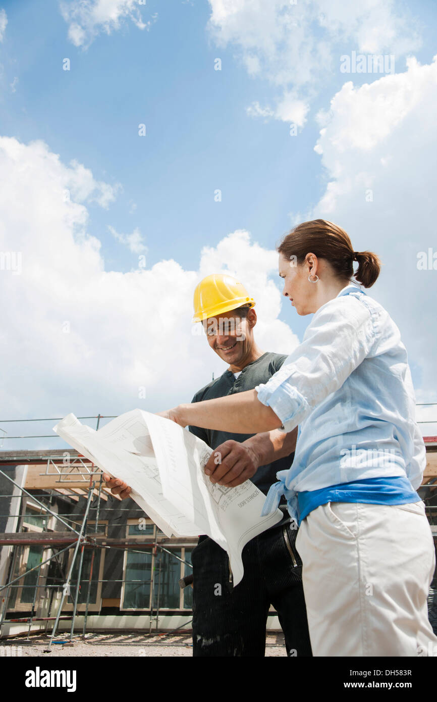 Bauleiter und Bauherren diskutieren Pläne auf einer Baustelle, Mannheim, Baden-Württemberg, Deutschland Stockfoto