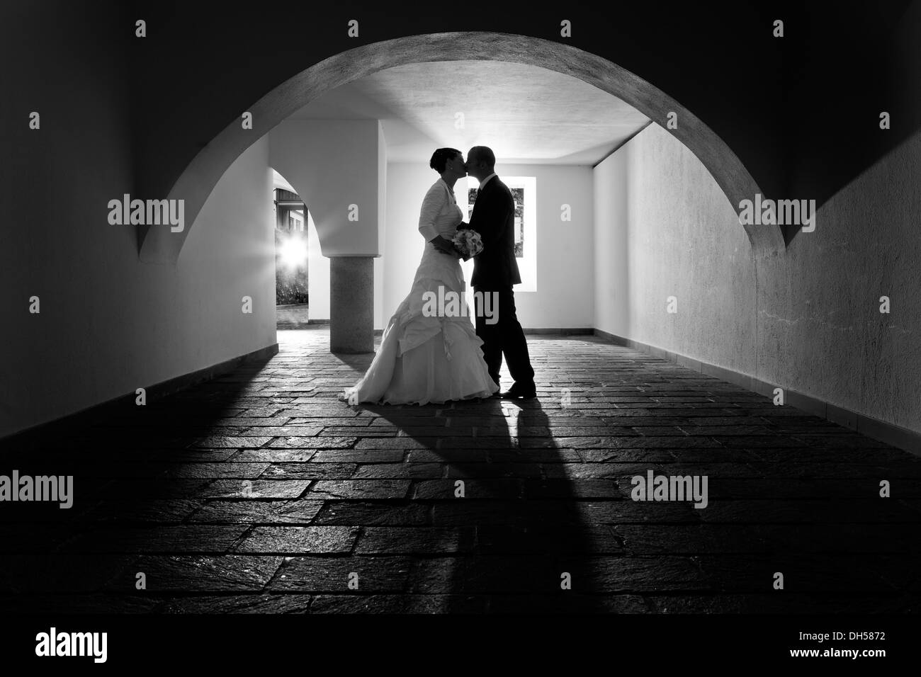 Braut und Bräutigam küssen unter dem Bogen der alten Tresor Rattenberg, Tirol, Österreich Stockfoto