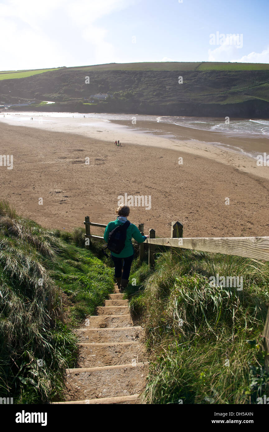 Frau geht ein Weg nach Mawgan Porth Beach in Cornwall England Stockfoto