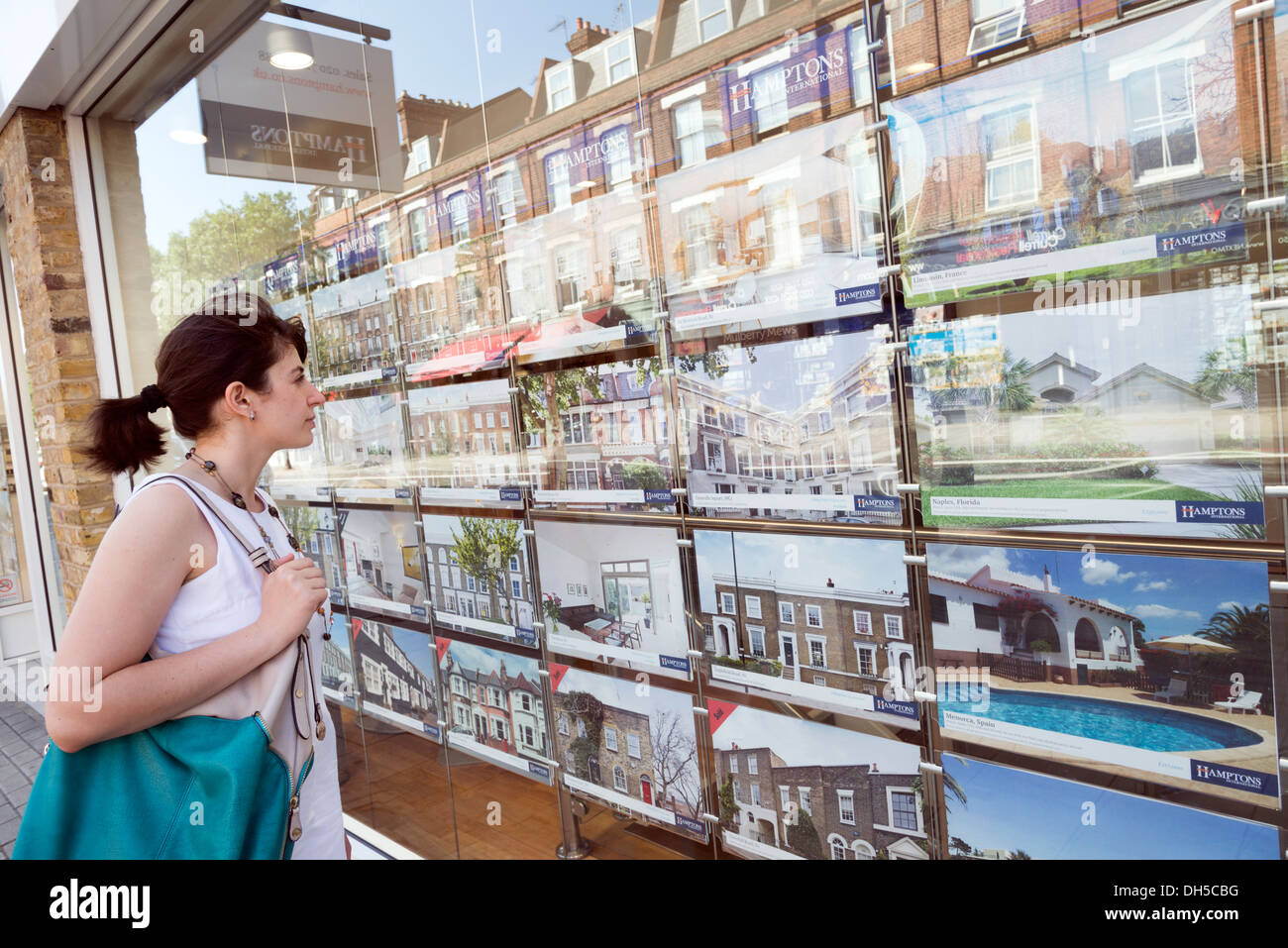 Junge Frau Häuser für Verkauf in Immobilienmakler Fenster, Islington, London, UK Stockfoto