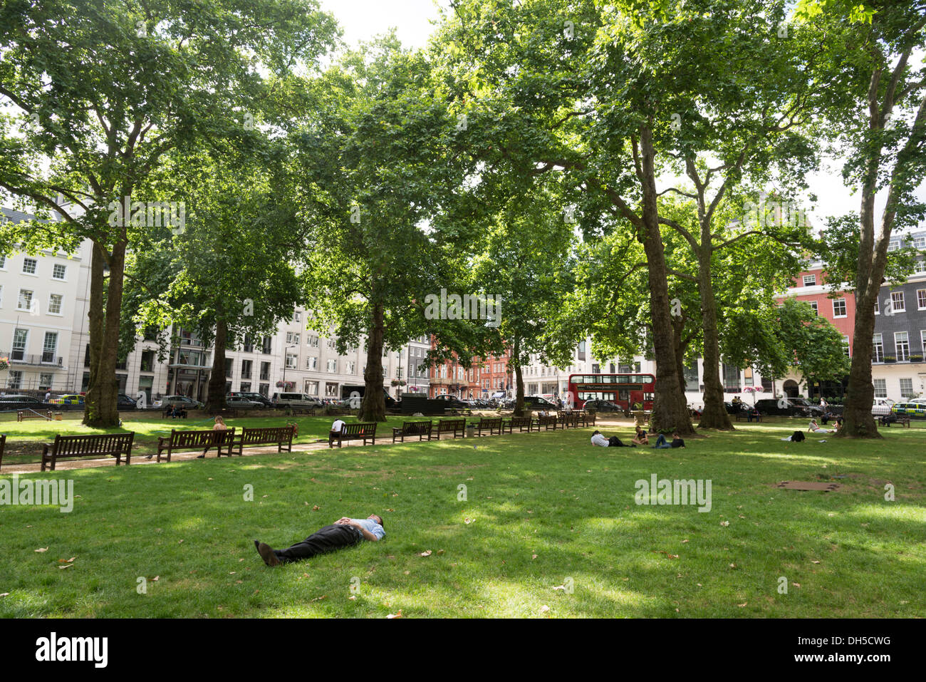 Büroangestellte, die sich in Berkeley Square Gardens, Mayfair, London, Großbritannien, ausruhen Stockfoto