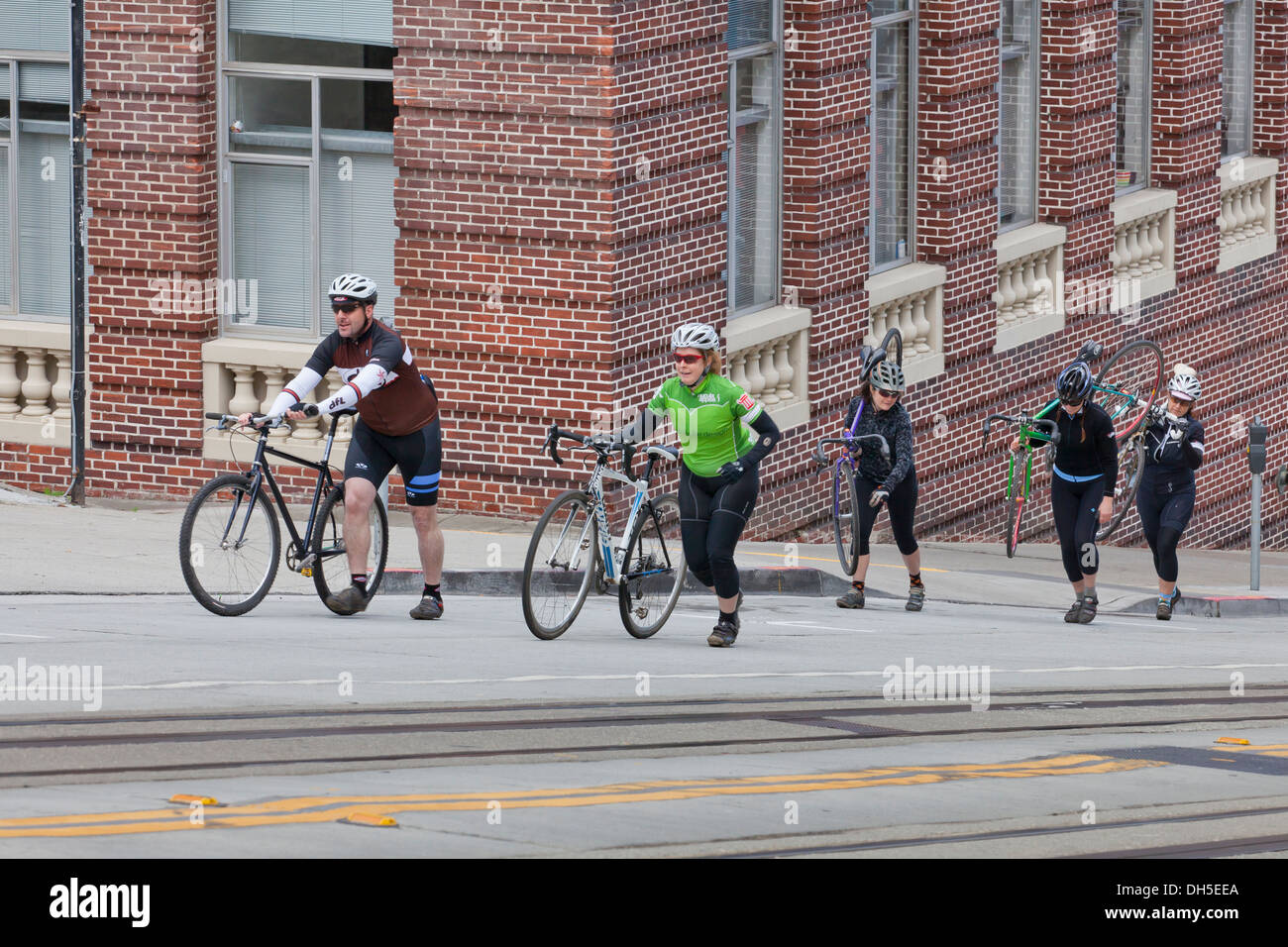 Radfahrer zu Fuß Fahrräder auf einer steilen Straße - San Francisco, Kalifornien, USA Stockfoto