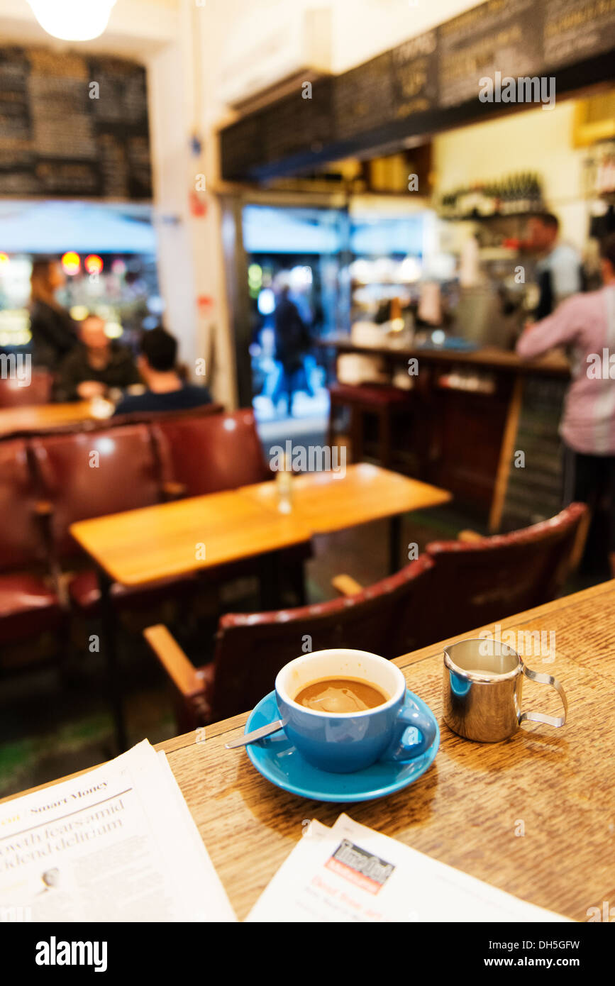 Lesen Sie die Zeitung und Time Out beim Trinken eines Kaffees in einem Café in Melbourne. Stockfoto