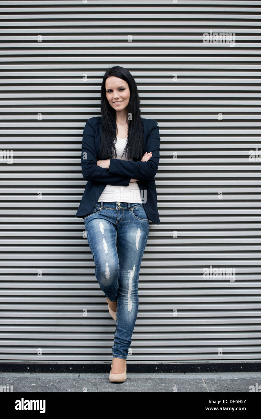 Outdoor Portrait von junge schöne Frau an Wand mit Streifen Stockfoto