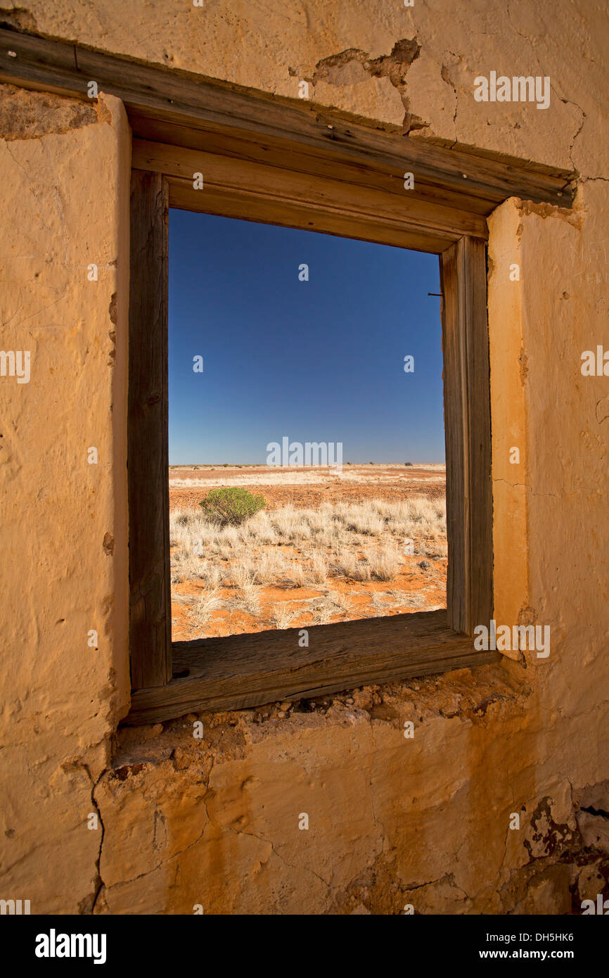 Blick auf Outback-Landschaft mit weiten, trockenen Ebenen und Himmel durch Fenster des zerstörten Gebäudes am Edwards Creek auf den Oodnadatta Track South Australia Stockfoto