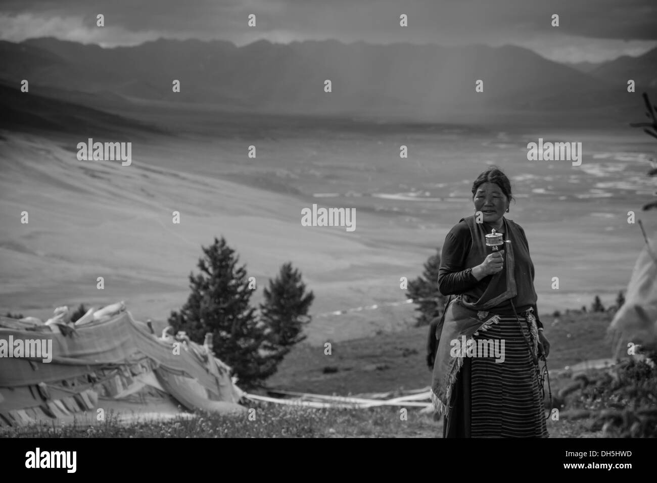 Eine tibetische Frau Spinnen eine Gebetsmühle Stockfoto