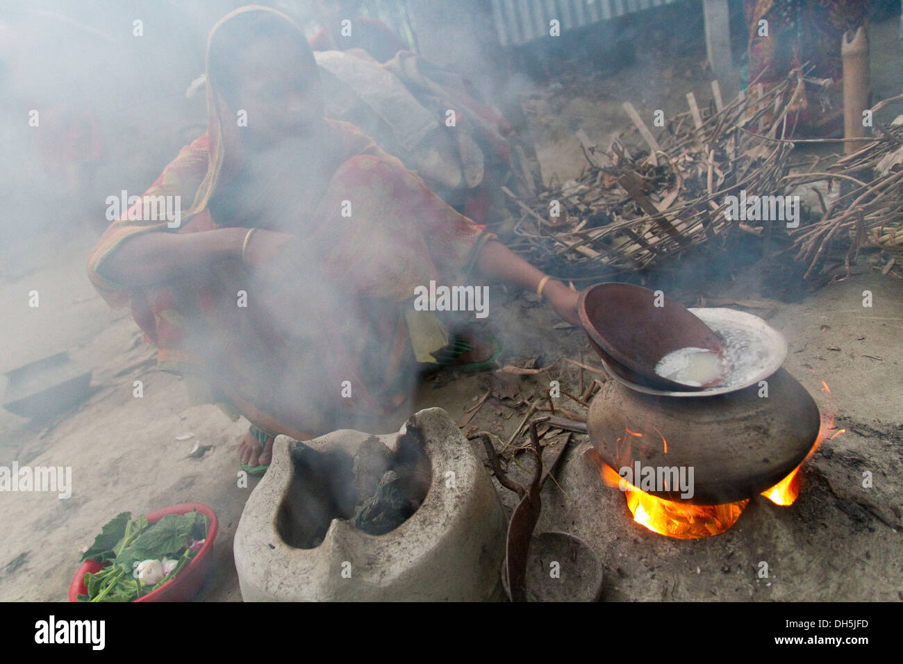 Kochen von Reis auf offenem Feuer, durch Rauch, Barakandi, Sirajganj, Bangladesch, Südasien verdeckt Gesicht Frau Stockfoto