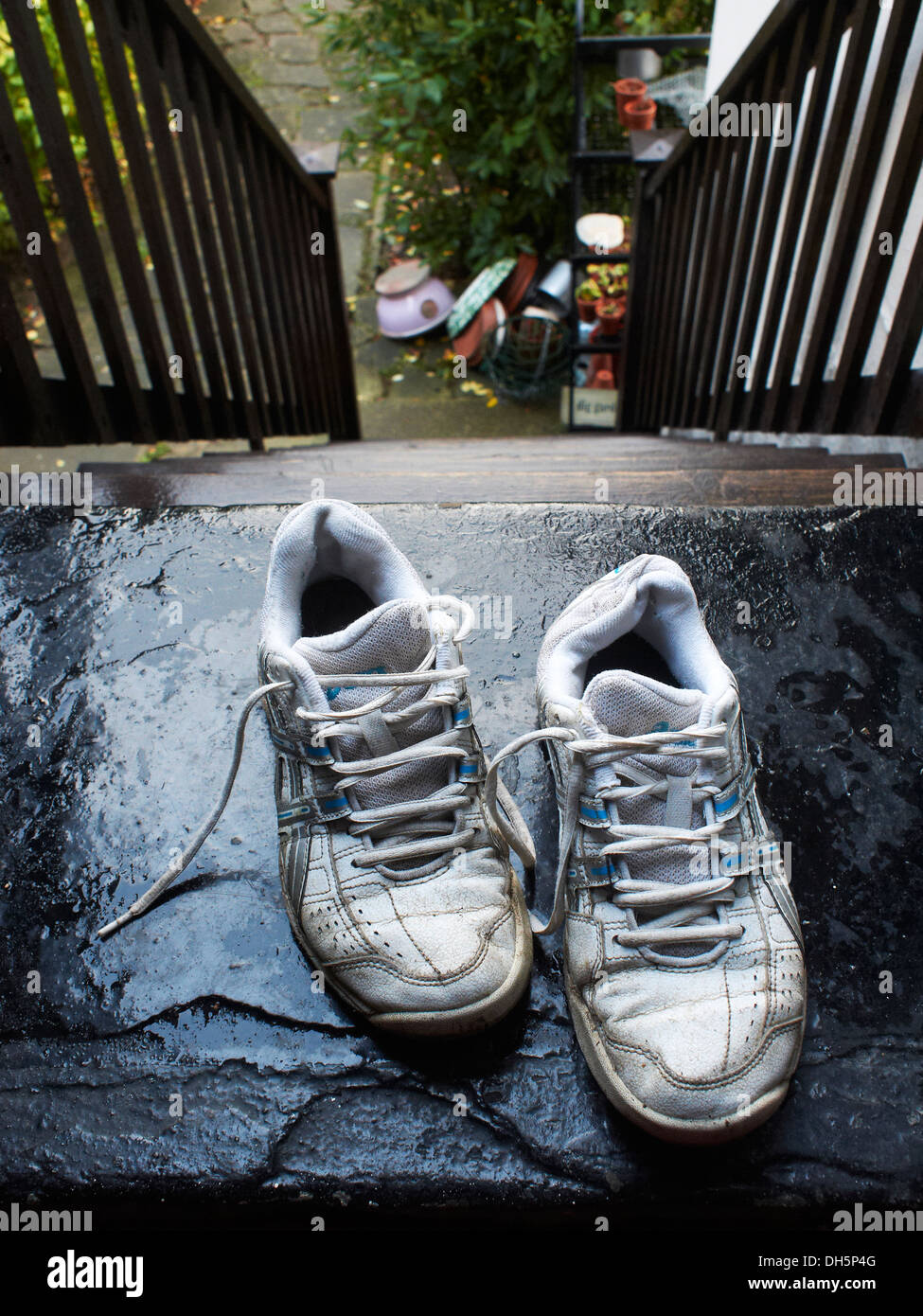 alte Turnschuhe auf der obersten Stufe der Treppe links Stockfoto