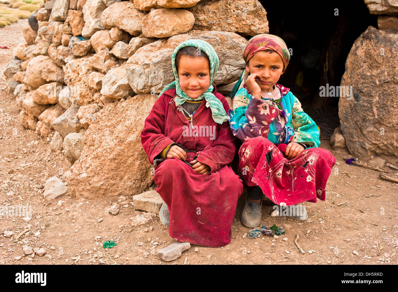 Zwei Mädchen mit Kopftuch, Nomadenkinder, Berber Leute, vor einem einfachen Stein Wohnung hocken Stockfoto