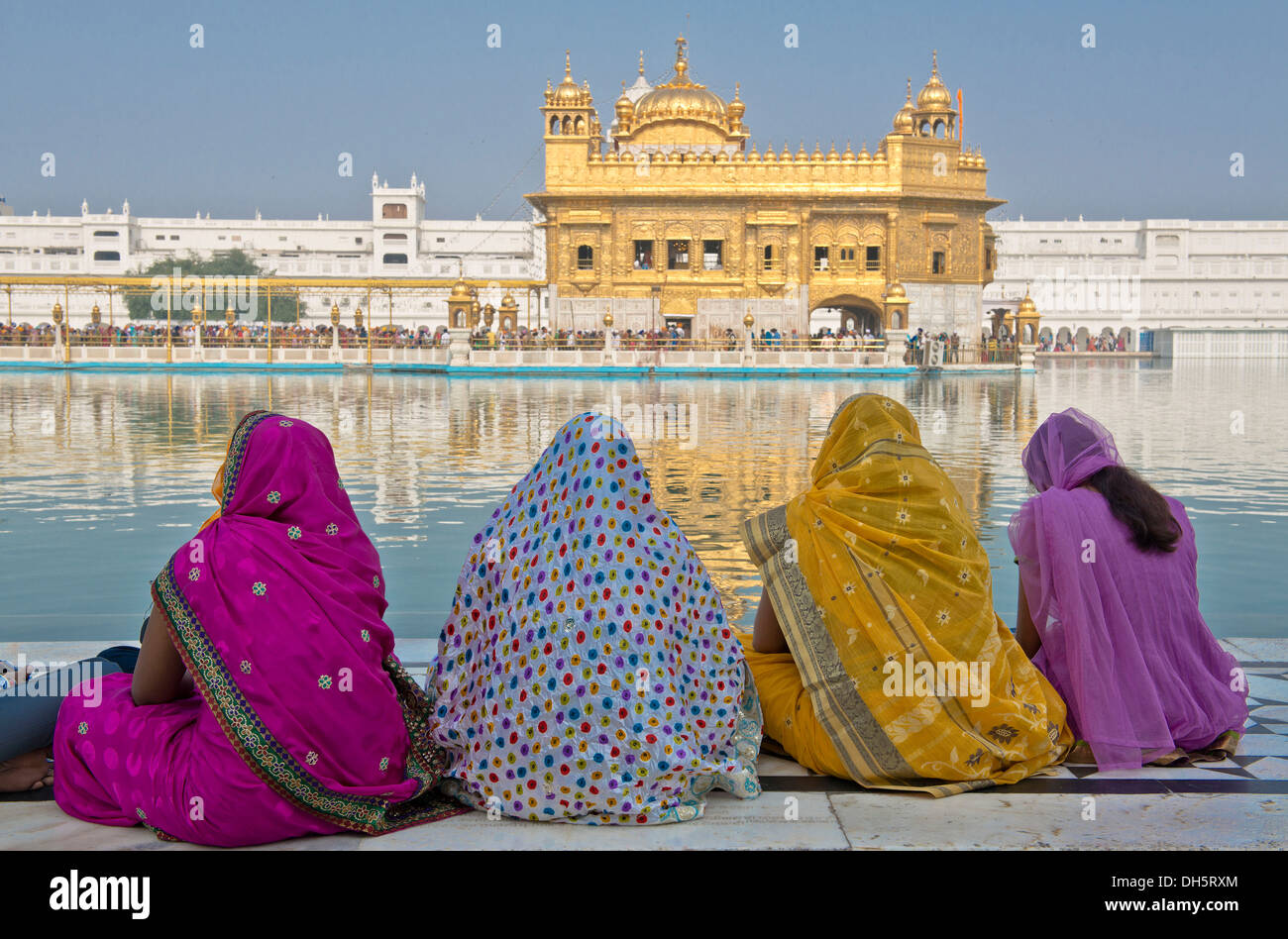 Indische Frauen tragen bunte Saris sitzt auf dem Rand des Wasser-Beckens von Amrit Sagar, Pilger oder Heiligen See, Harmandir Stockfoto