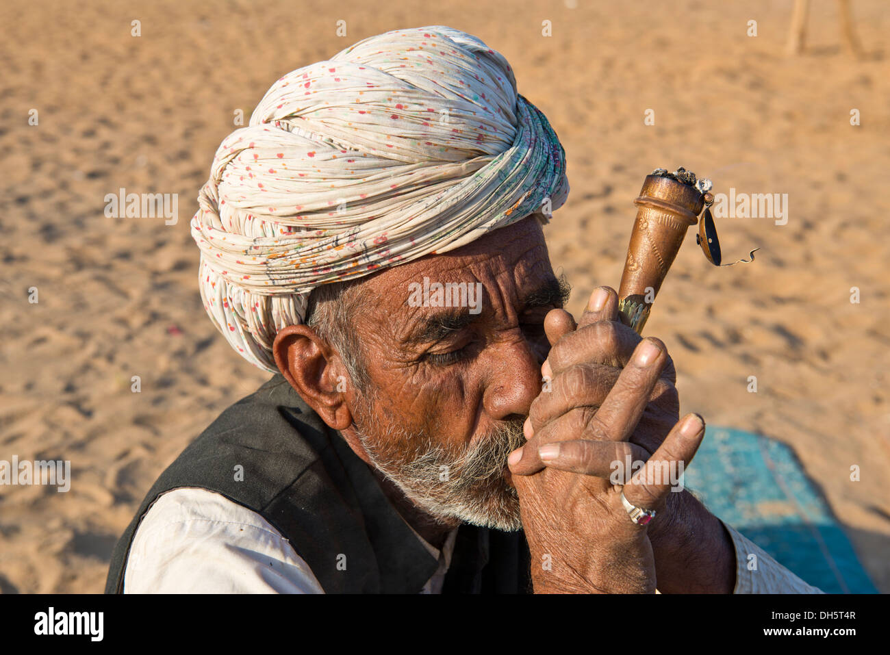 Indischer Mann mit einem Turban raucht eine Pfeife Hash, Pushkar, Rajasthan, Indien Stockfoto