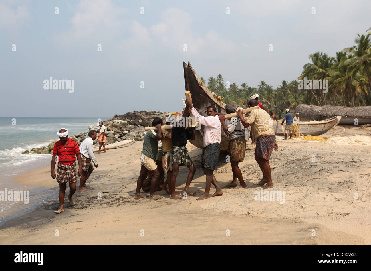 Fischer, schob ihr Boot aus dem Wasser auf den Strand, Varkala, Kerala, Indien, Asien Stockfoto