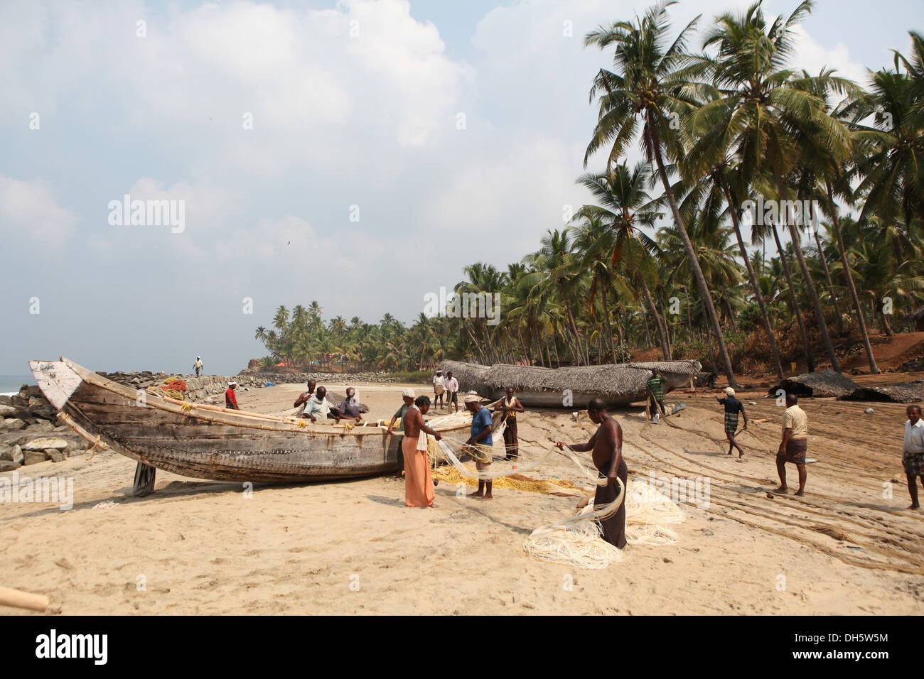 Gruppe von Fischern sortieren ihre Netze auf den Strand, Varkala, Kerala, Indien, Asien Stockfoto