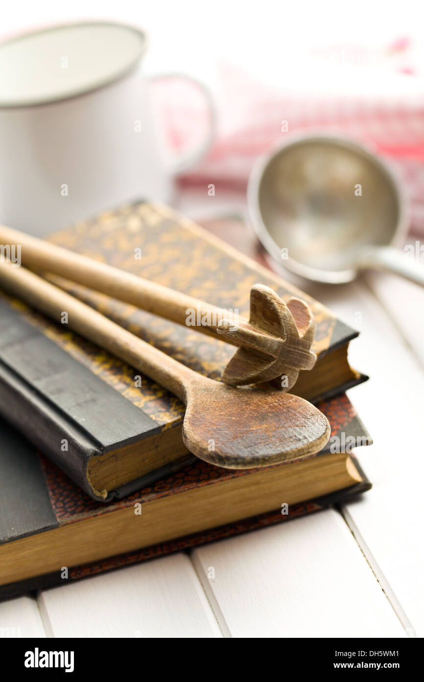 Kochbuch mit alten Küchenutensilien auf weißer Holztisch Stockfoto