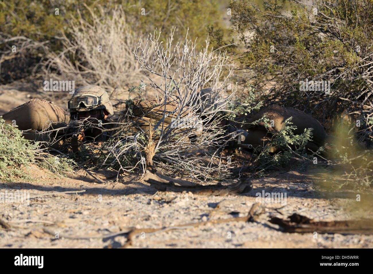 Bieten Sie MARINE CORPS AIR STATION YUMA, Arizona – Lance Cpls. Bryce Rhodes (links) und Paul Paddock, Assaultmen mit Bravo Company, 1. Bataillon, 7. Marineregiment, Sicherheit aus einer kämpfende Position während eine defensive Übung hier, 15. Oktober 2013. Die Mari Stockfoto