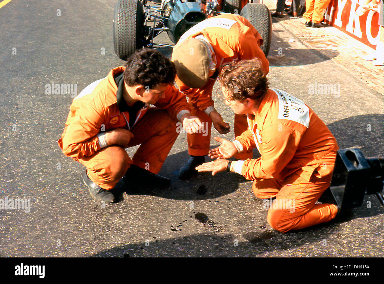 Mechanik Alan Challis, Willie Southcott und Dennis Perkins untersuchen ausgelaufenen Flüssigkeit aus ihren BRM P261. GP von Großbritannien 1966. Stockfoto