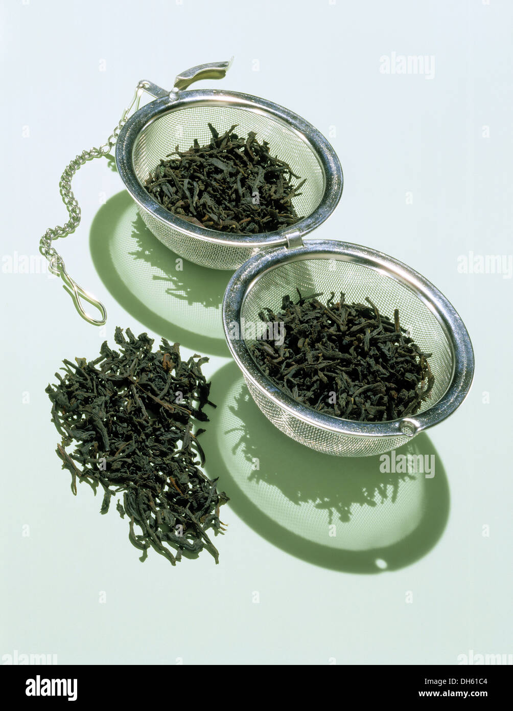 Eine geöffnete Teesieb mit losen getrockneten grünen Tee Blätter. Stockfoto