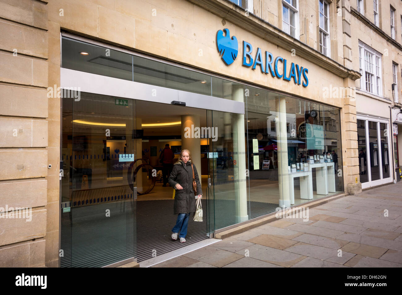 eine Frau, die zu Fuß aus Barclays Bank-Filiale, UK Stockfoto