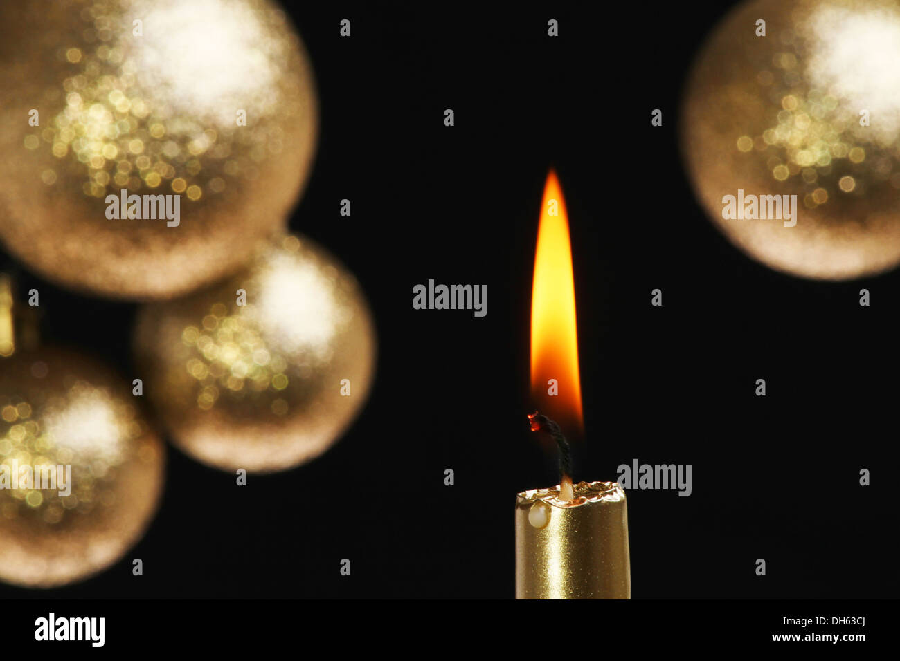 Goldene Kerze mit Weichzeichner gold Kugeln vor schwarzem Hintergrund Stockfoto