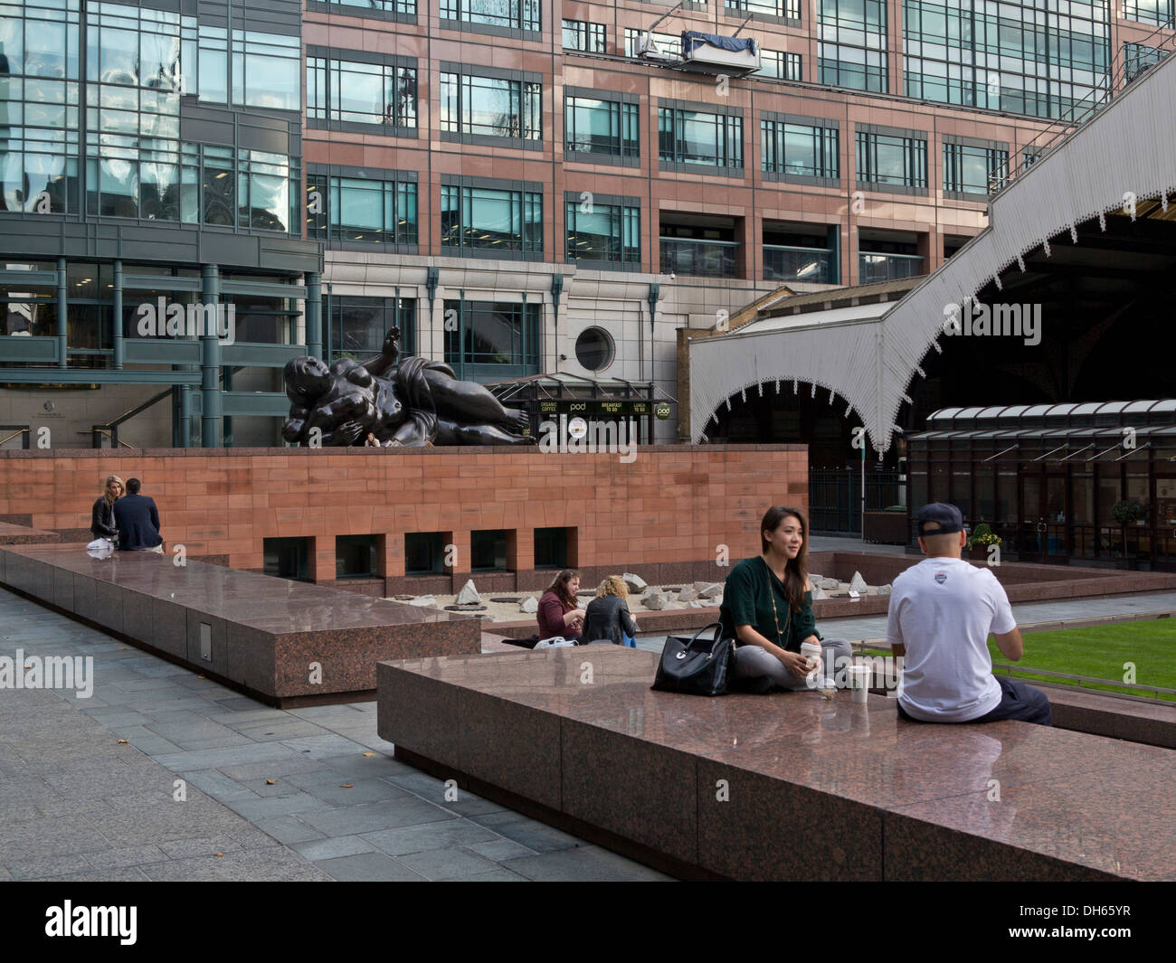 Menschen mit einem Snack in der Nähe von Liverpool Street Station mit Statue von Botero im Hintergrund in London, UK Stockfoto