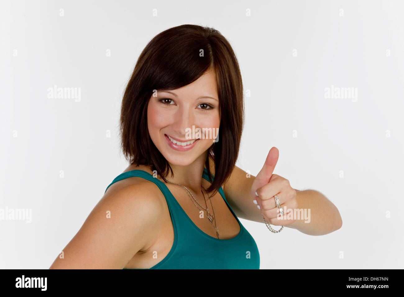 Lächelnde junge Frau macht Daumen hoch Geste Stockfoto
