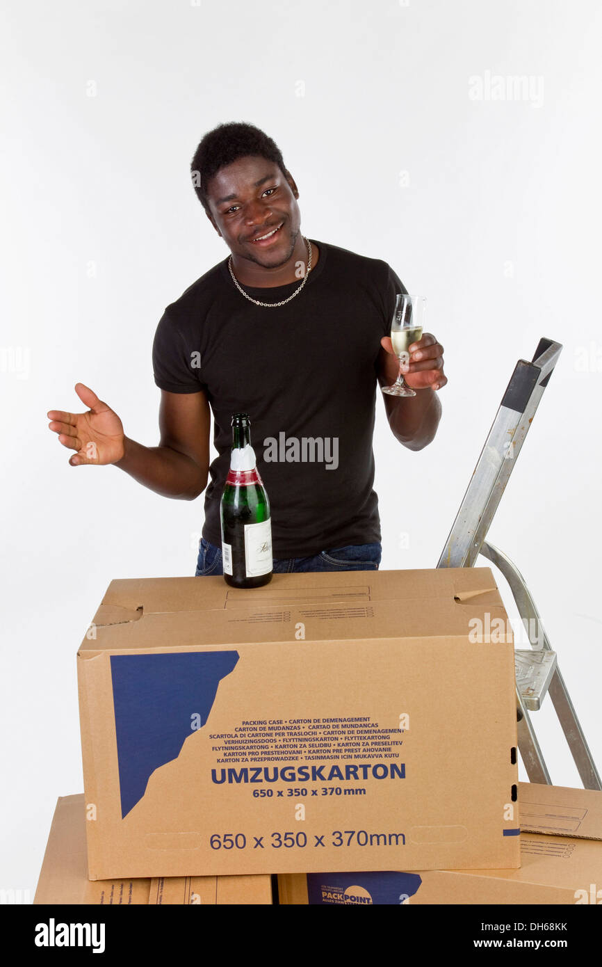 Junge schwarze Mann mit beweglichen Kästen und eine Flasche Champagner Stockfoto