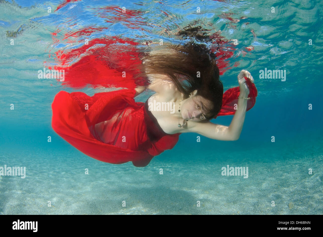 Eine junge Frau mit großen Haar posiert im Ägäischen Meer unter Wasser. Griechenland Stockfoto