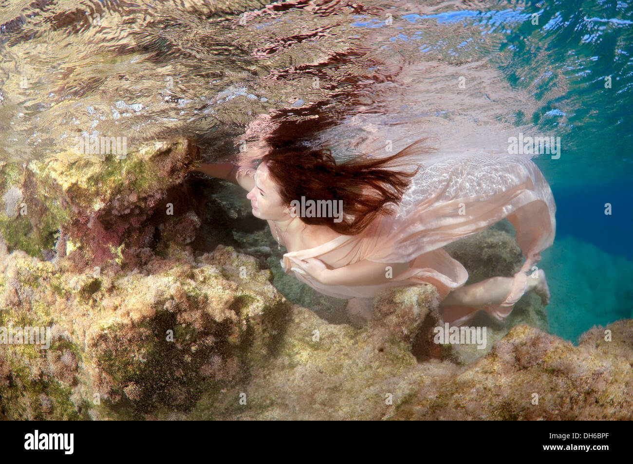 Eine junge Frau mit großen Haar posiert im Ägäischen Meer unter Wasser. Griechenland Stockfoto
