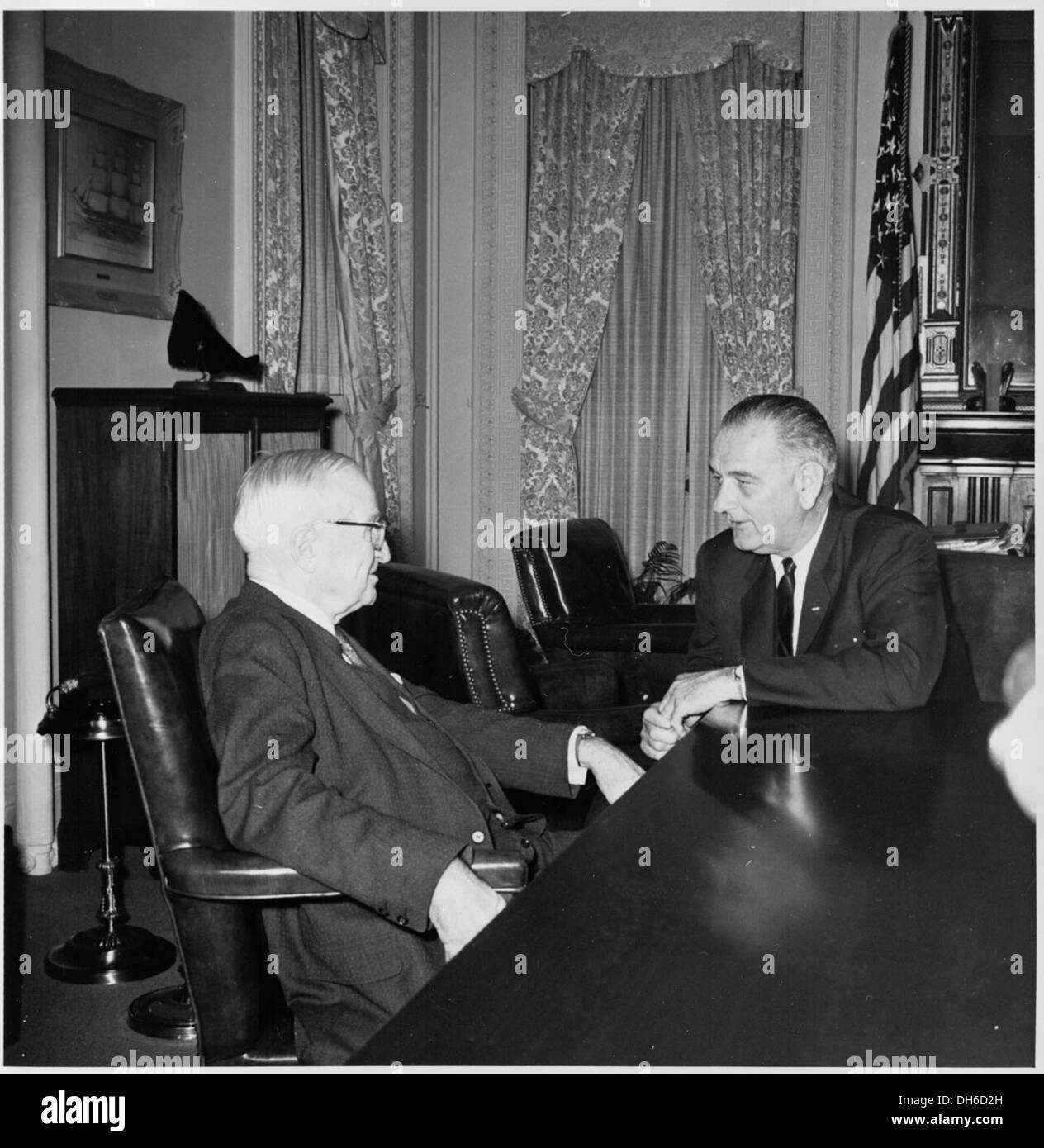 Ein Foto, das den ehemaligen Präsidenten Harry S. Truman zusammen mit Präsident Lyndon B. Johnson fotografiert hat und wahrscheinlich während einer Tagung oder Veranstaltung im Weißen Haus aufgenommen wurde, um das Ableben der politischen Führung in der Geschichte der USA hervorzuheben. Stockfoto