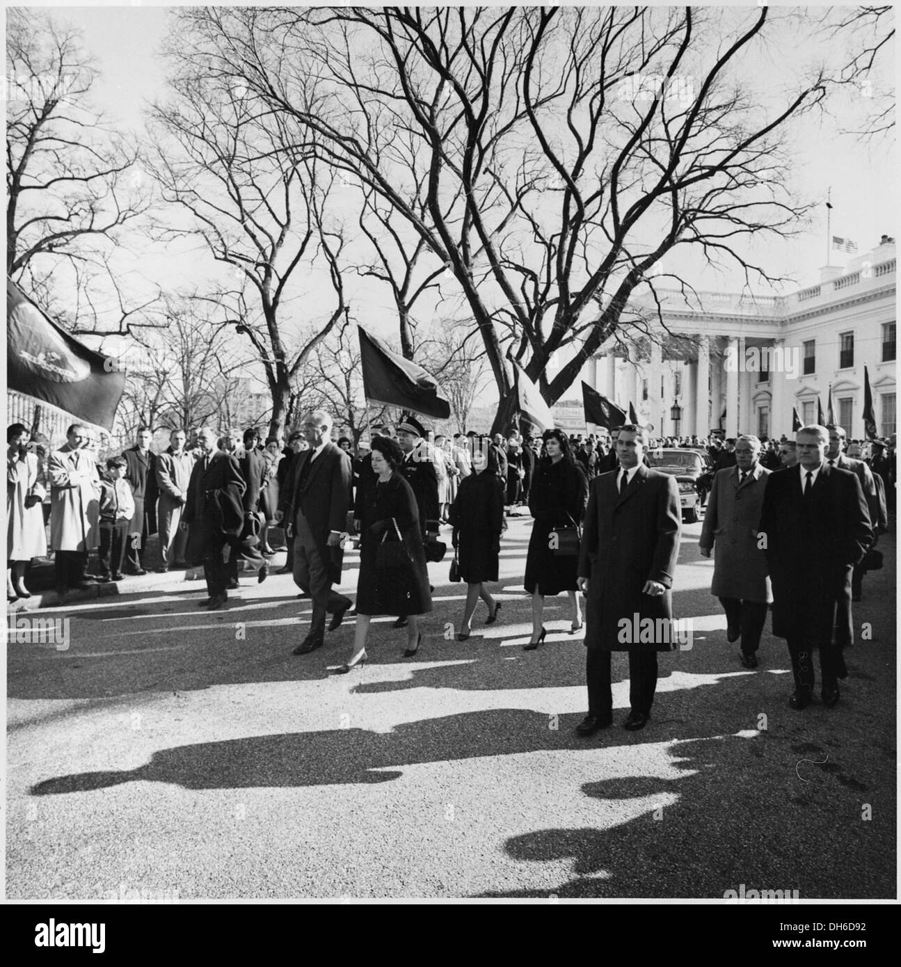 Dieses Foto zeigt Präsident Lyndon B. Johnson und seine Familie, die während einer Trauerprozession aus dem Weißen Haus spazieren, ein düsterer Moment in der amerikanischen Geschichte. Stockfoto