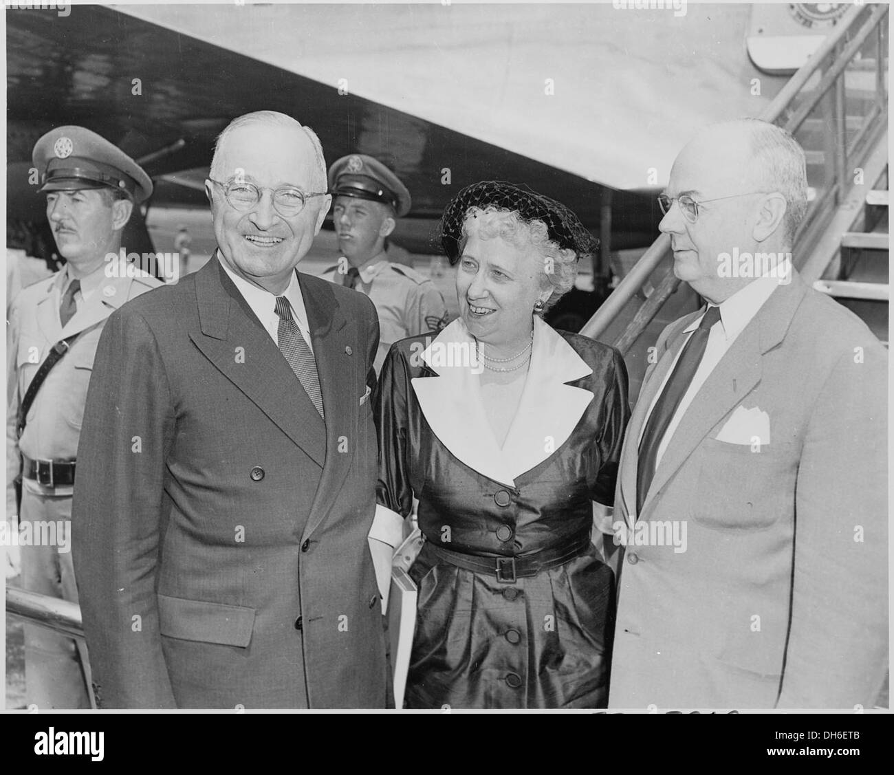 Präsident Harry S. Truman steht mit First Lady Bess Truman und Finanzminister John Snyder an einem Flughafen. Das Foto zeigt einen Moment des öffentlichen Engagements während Trumans Präsidentschaft. Stockfoto