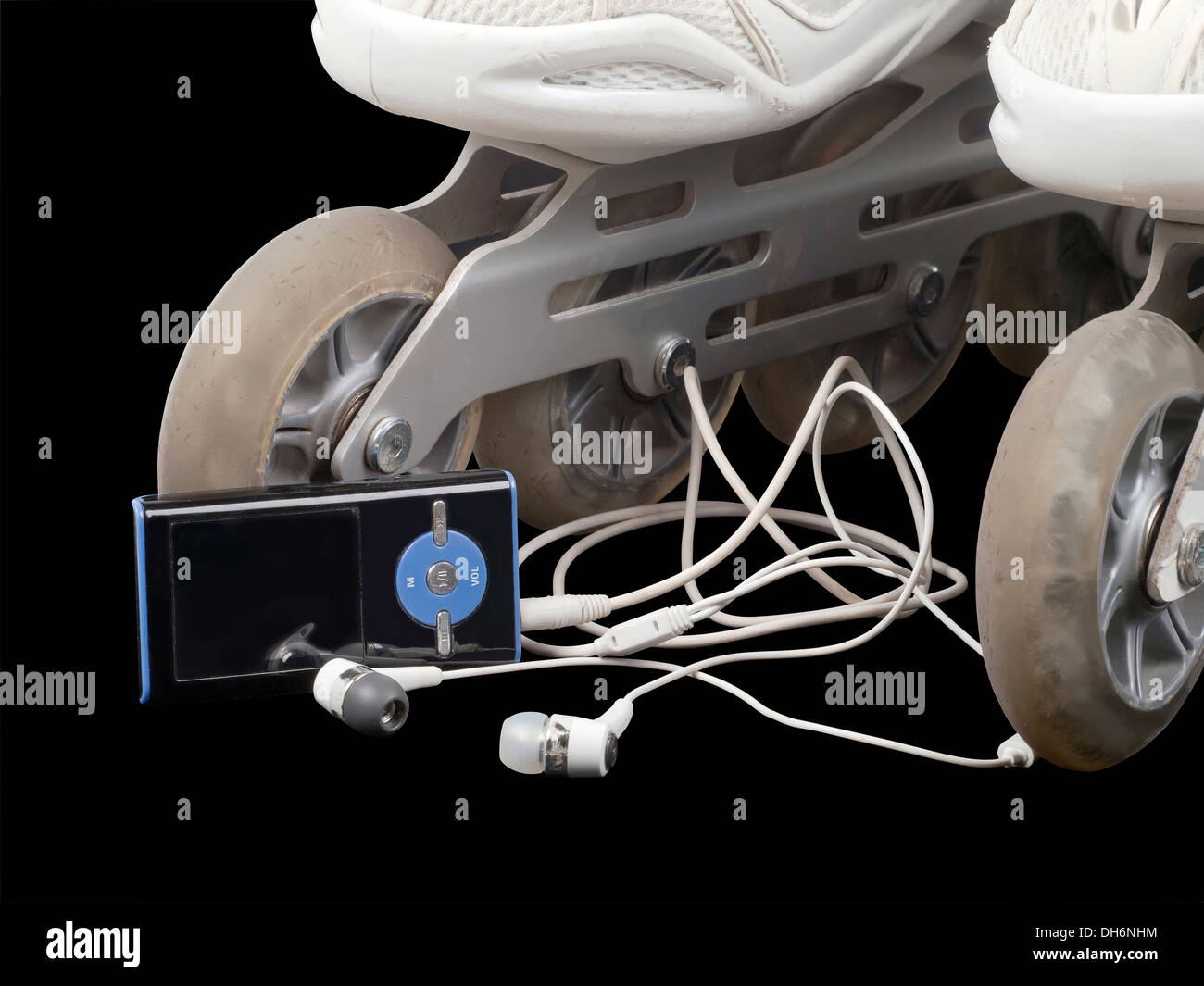 Rollschuhe und MP3-Player mit Kopfhörern auf schwarzem Hintergrund isoliert Stockfoto