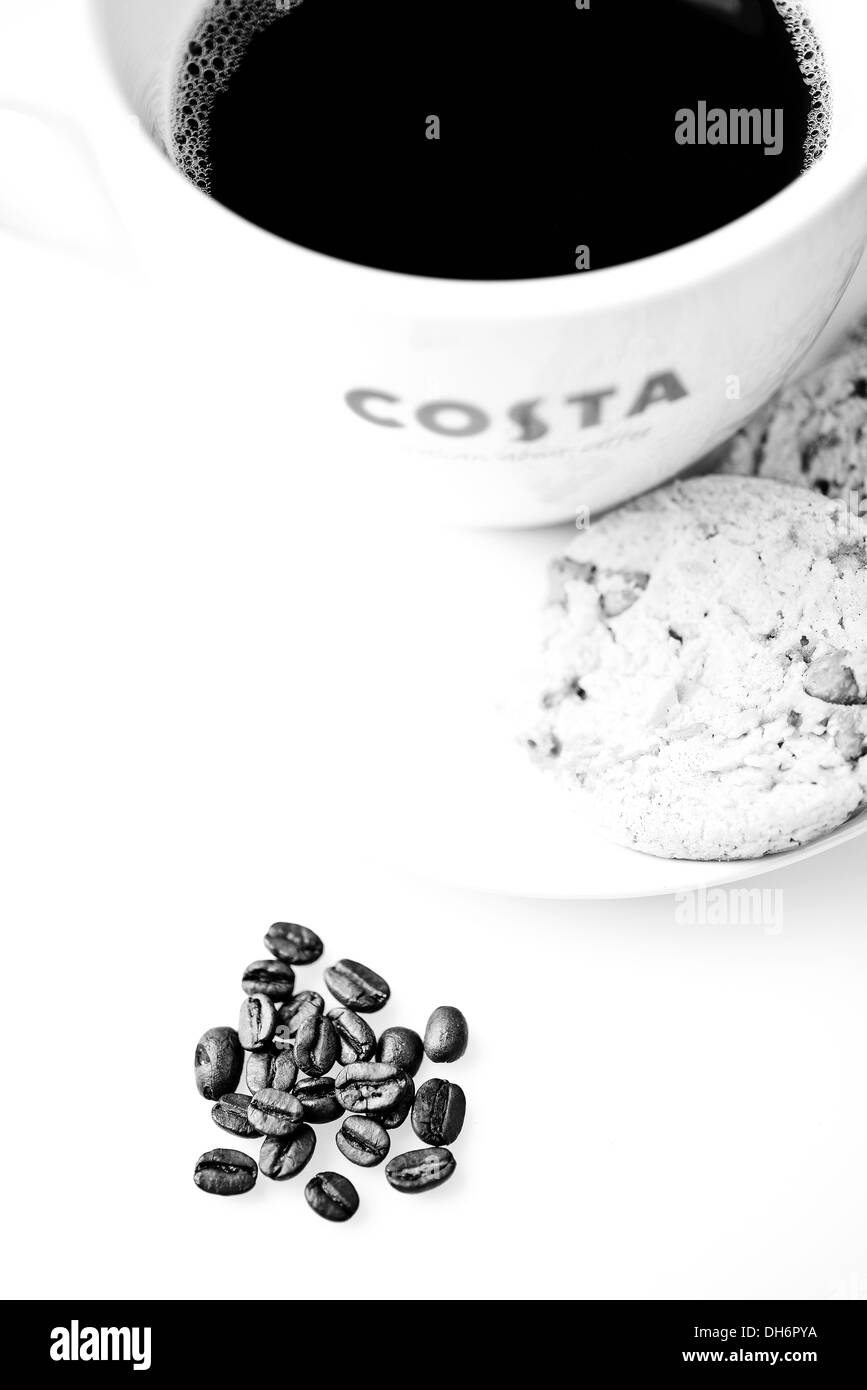 Costa-Kaffee mit Choc Chip Cookies und Kaffee Bohnen auf dem Tisch Stockfoto