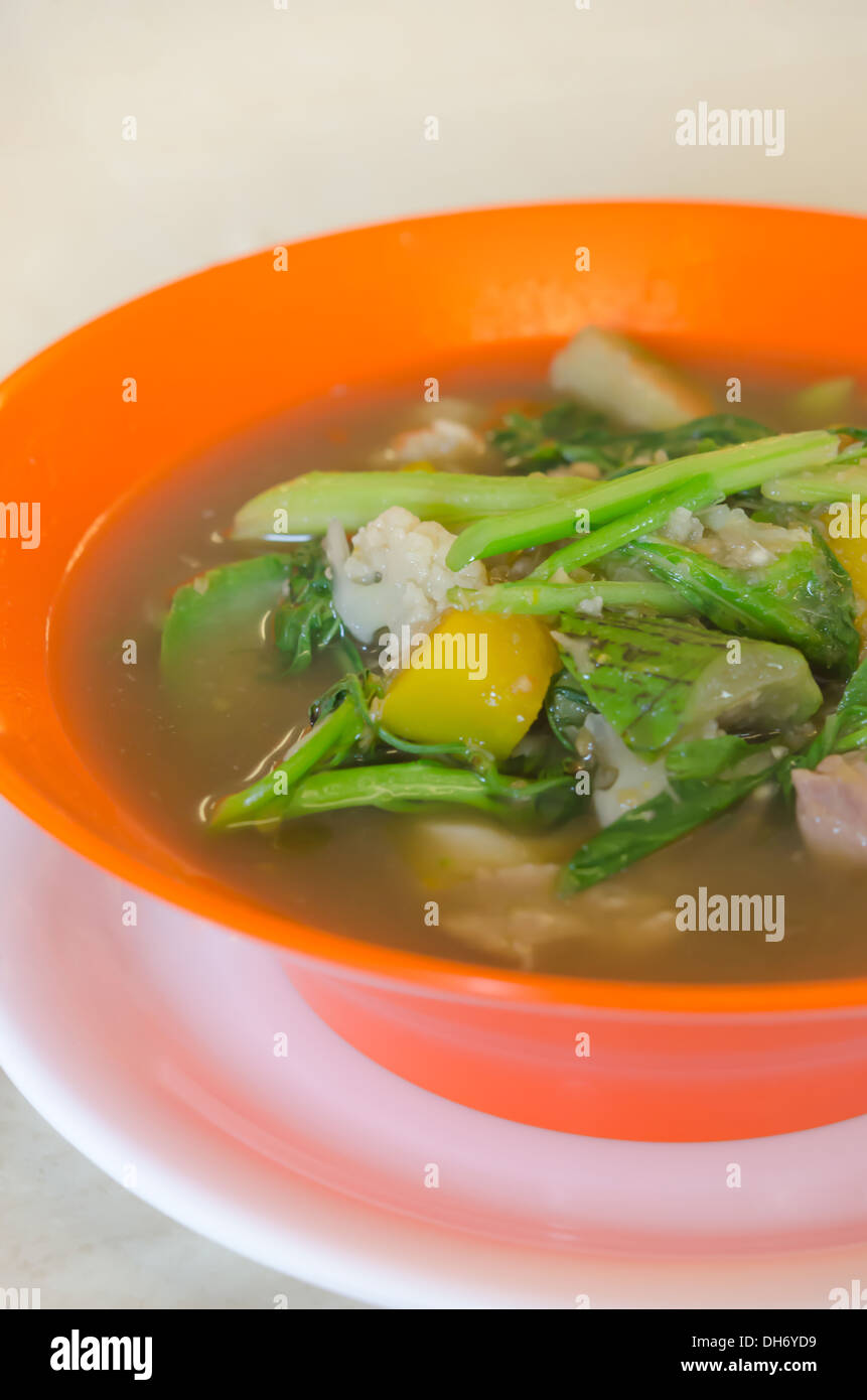 herzhafte dicke Suppe aus Schweinefleisch, Gewürze und Gemüse-Mischung in orange Schüssel, asiatische Suppe Stockfoto