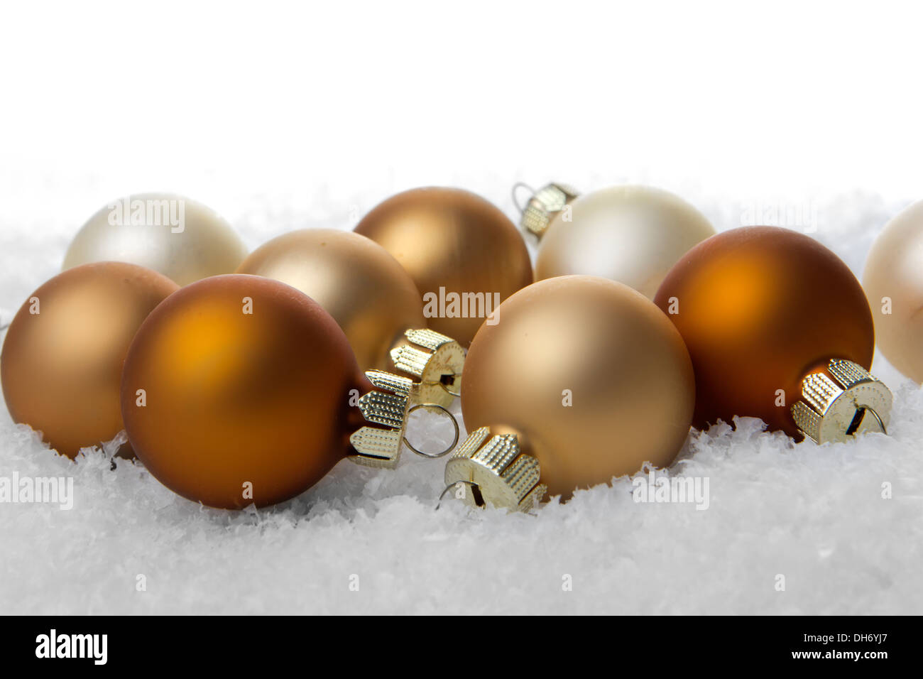 Weihnachten, Crème Weihnachtskugeln auf Kunstschnee mit weißem Hintergrund Stockfoto