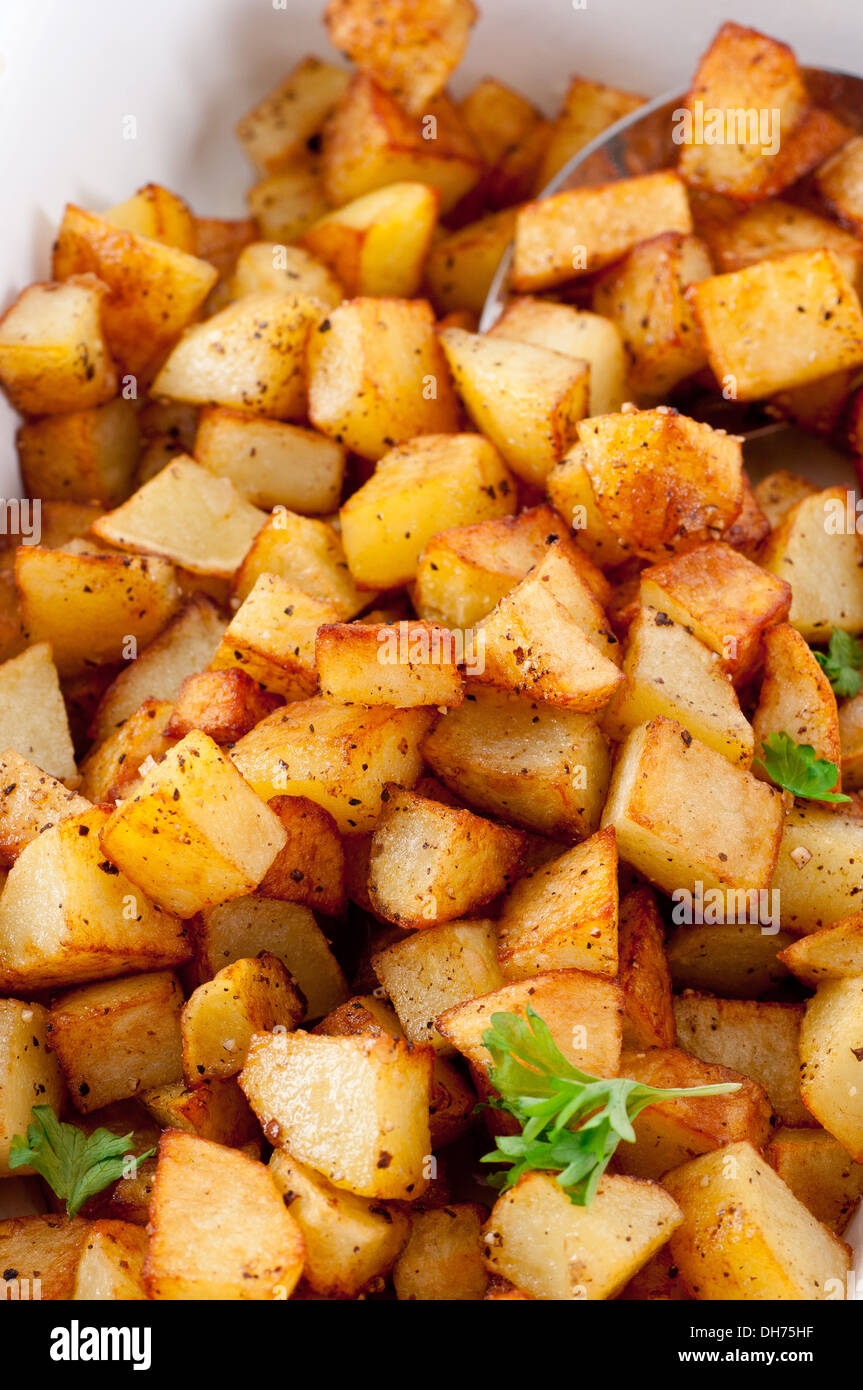 Pfanne gebratenen Kartoffelwürfel mit Salz und schwarzem Pfeffer gewürzt. Stockfoto