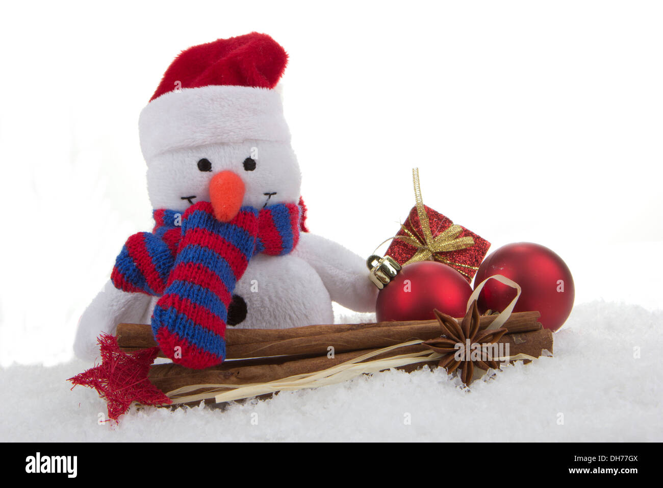 Schneemann (Spielzeug) mit Weihnachtsdekoration und Kunstschnee Stockfoto