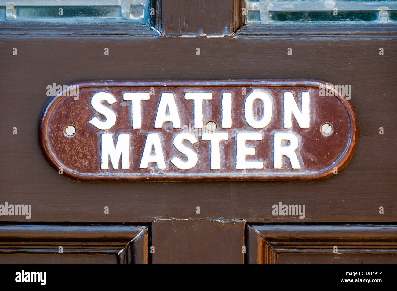 Ein Metall-Station-Master-Typenschild an einer braun lackierten Tür am geschlossenen Wolferton-Bahnhof in Norfolk. Stockfoto