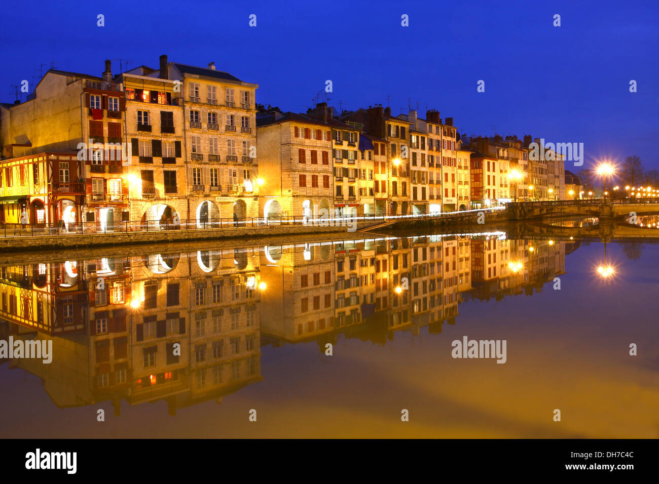 Blaue Stunde und Reflexionen über Nive Fluss, Petit Bayonne, Baskenland. Stockfoto