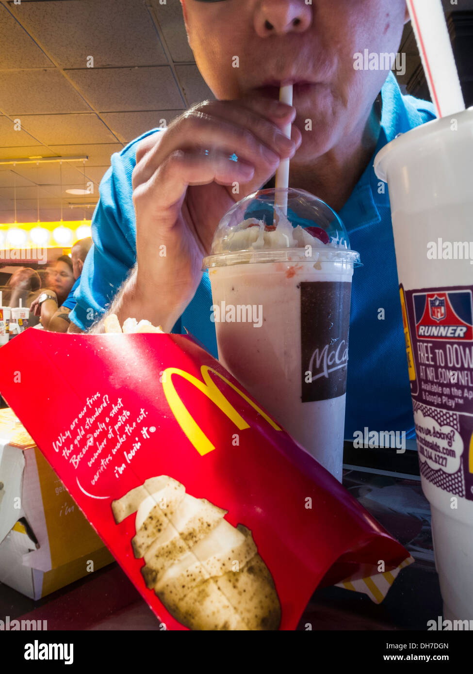 Menschen Essen bei McDonald's Restaurant, Telefon, Pommes Frites und Milkshake Mahlzeit, NYC, USA Stockfoto