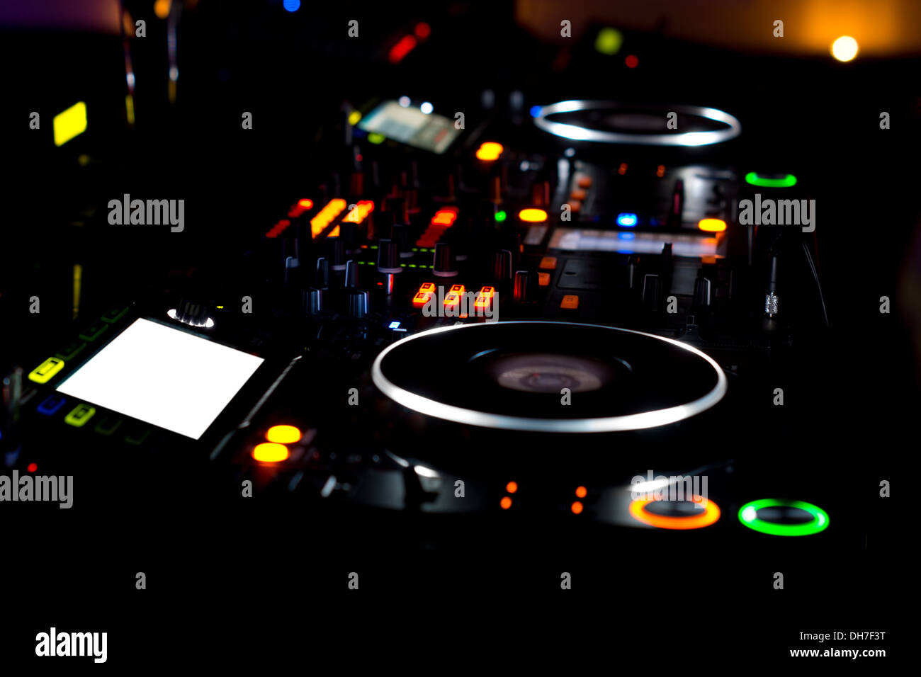 Bunte DJ-Deck und Plattenspieler beleuchtet in der Nacht in eine Diskothek, Konzert oder Party mit einer Nahaufnahme der Ausrüstung Stockfoto