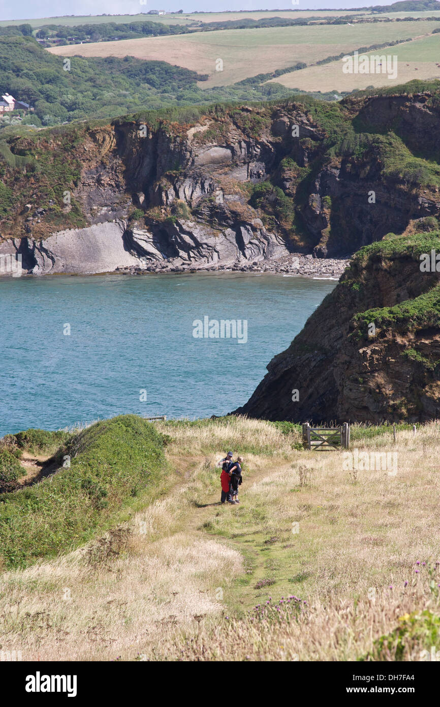 Paar zu Fuß entlang der Küstenweg mit blauem Meer und Klippen im Hintergrund. Stockfoto