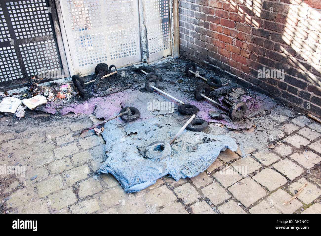 Geschmolzene Wheelie bin Ablagen Kunststoff Brandstiftung Vandal verbrannt Stockfoto