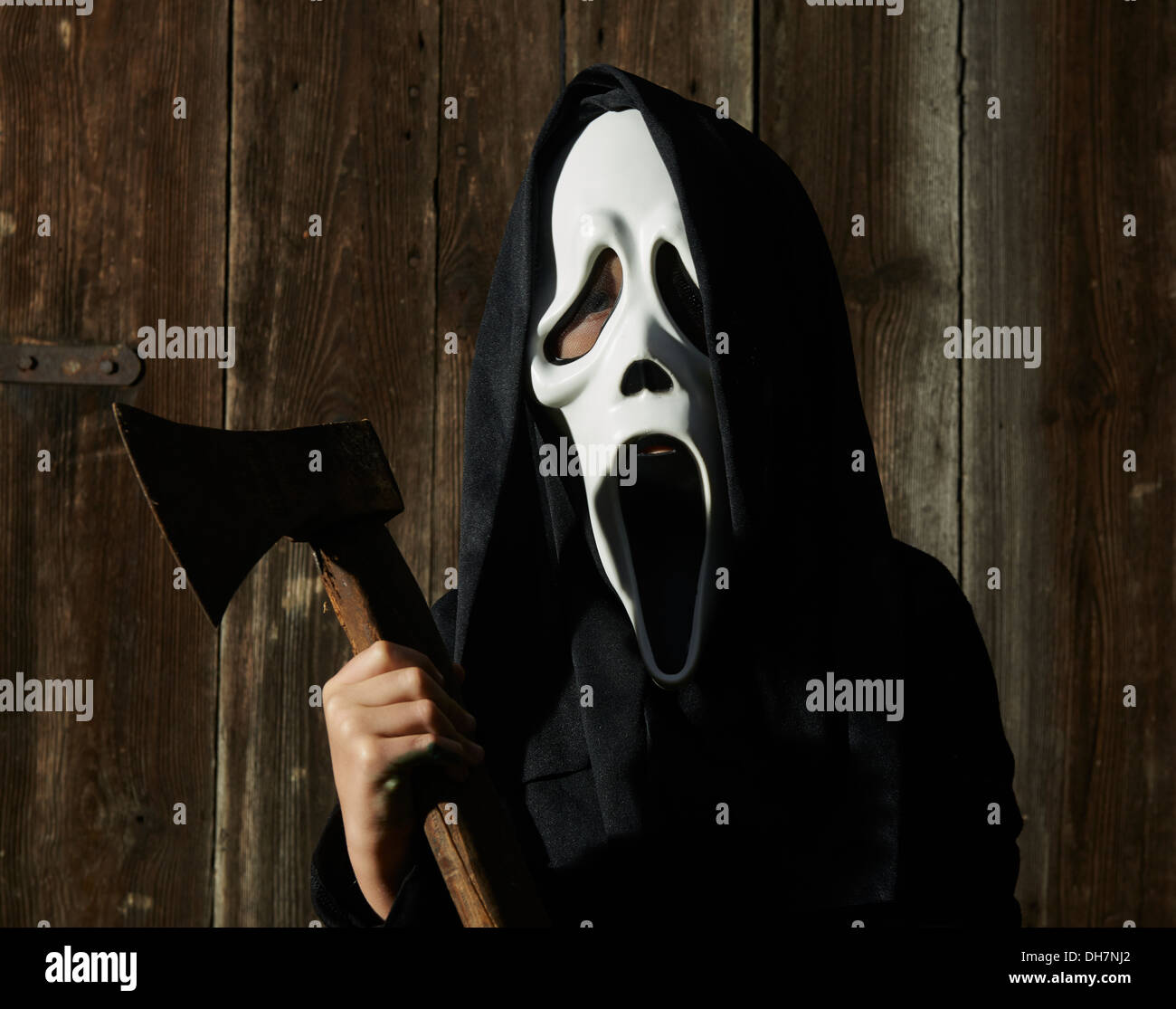 Mann in beängstigend "Schrei" Maske hält Axt. Maske der Sensenmann. Weißen  Geistermaske Karneval und schwarze Kapuze. Scary Movie Film Stockfotografie  - Alamy