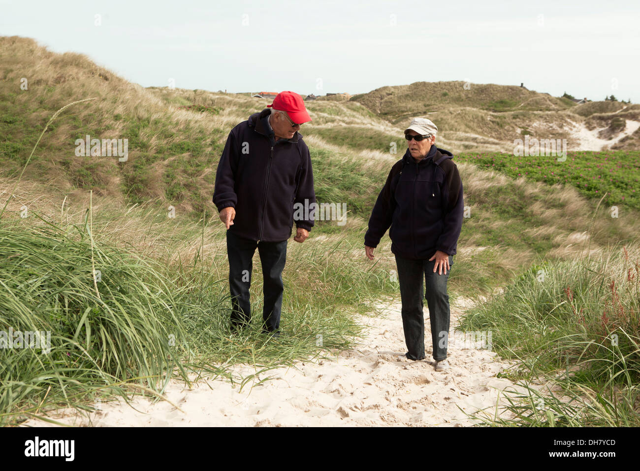 Spazieren Sie zu Fuß in den Dünen, Rentner machen Urlaub am Strand in Dänemark und gegen Stockfoto
