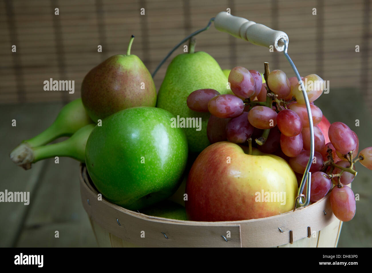 Früchte Korb Apfel Birne Banane Trauben Stockfoto