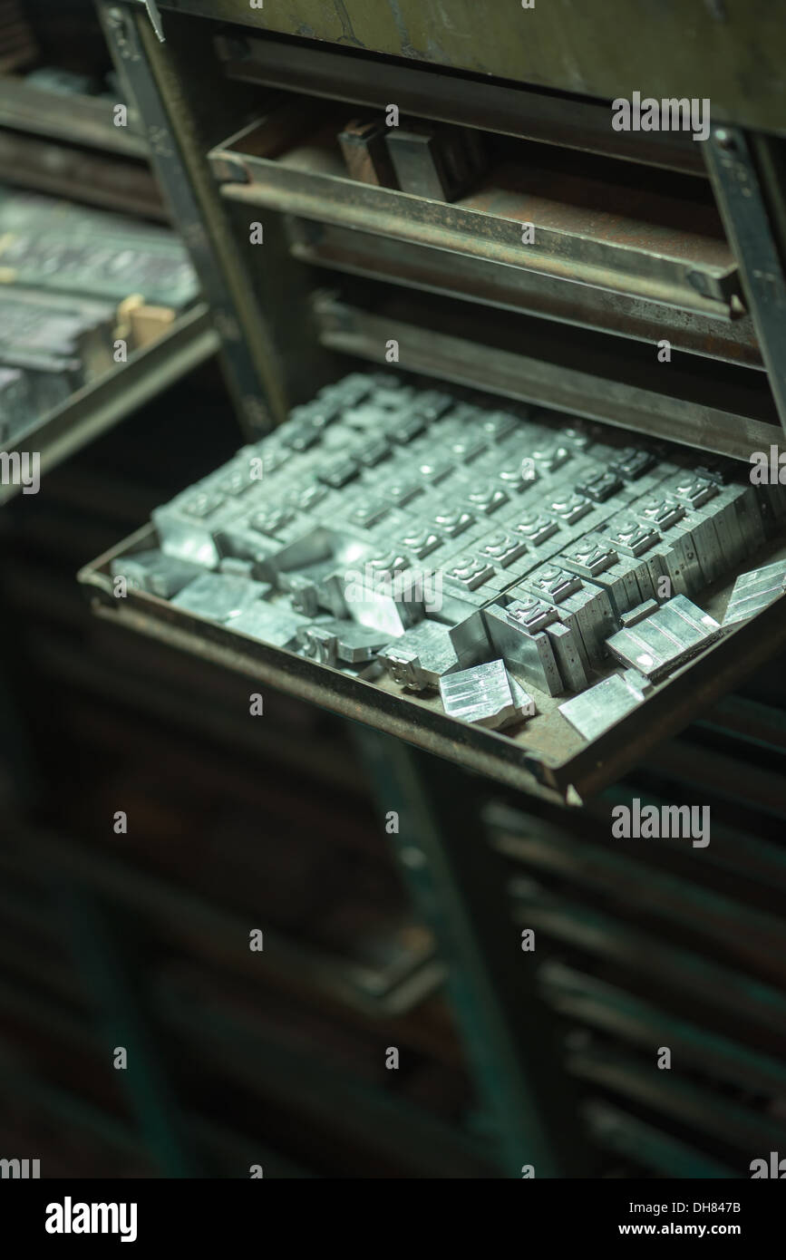 Ein altes Metall Aktenschrank voller antiker industrielle Printpresse Briefmarken. Stockfoto