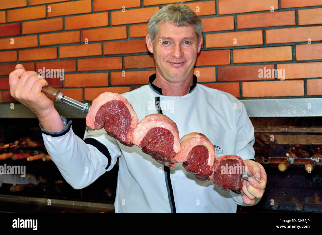 Brasilien, Bento Goncalves: Grill, den Koch mit riesigen Fleisch bereit für spucken in den Grill Restaurant Churrascaria Ipiranga setzen Stockfoto